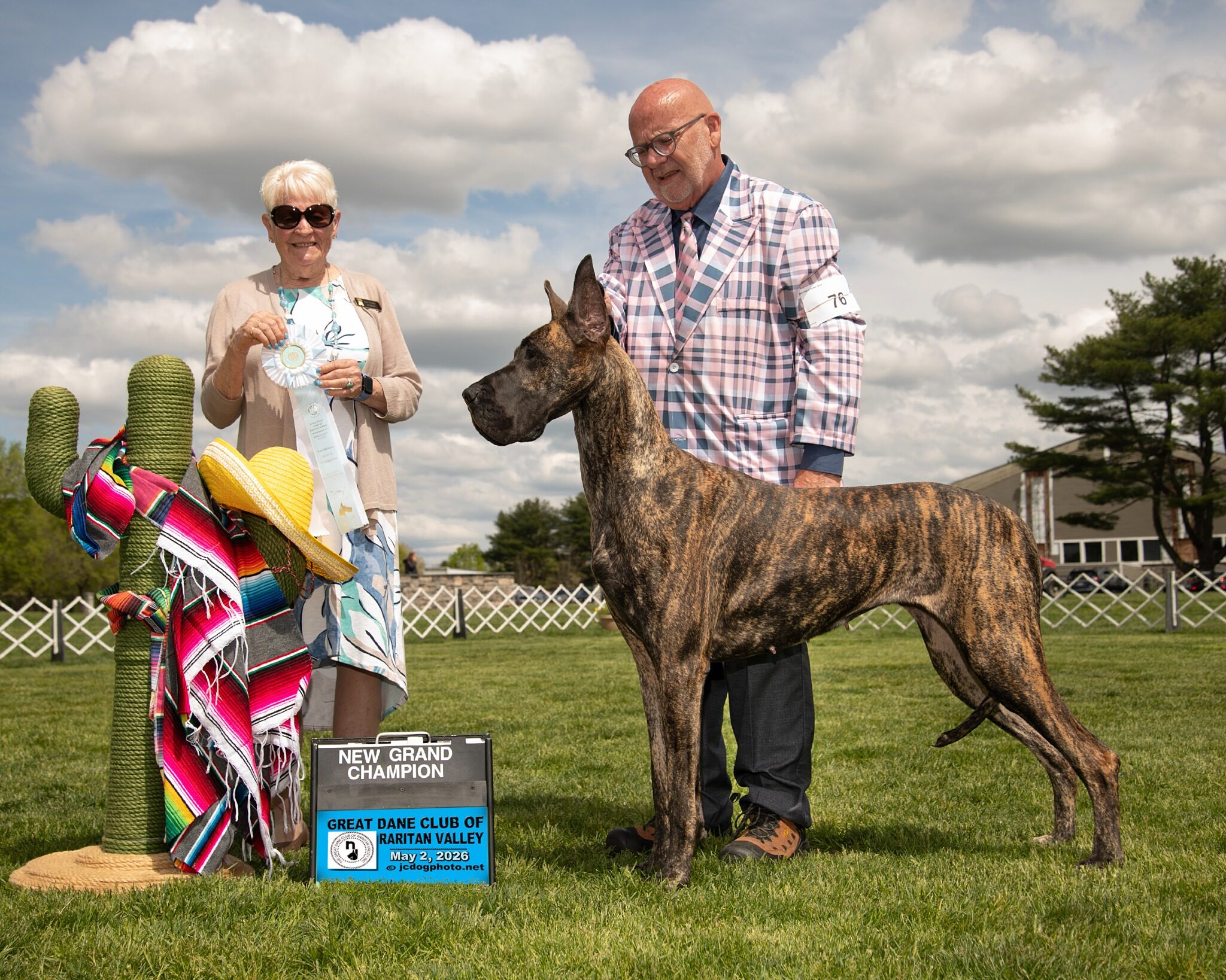 Jewel, the brindle AKC Grand Champion dam, posed with her handler and award